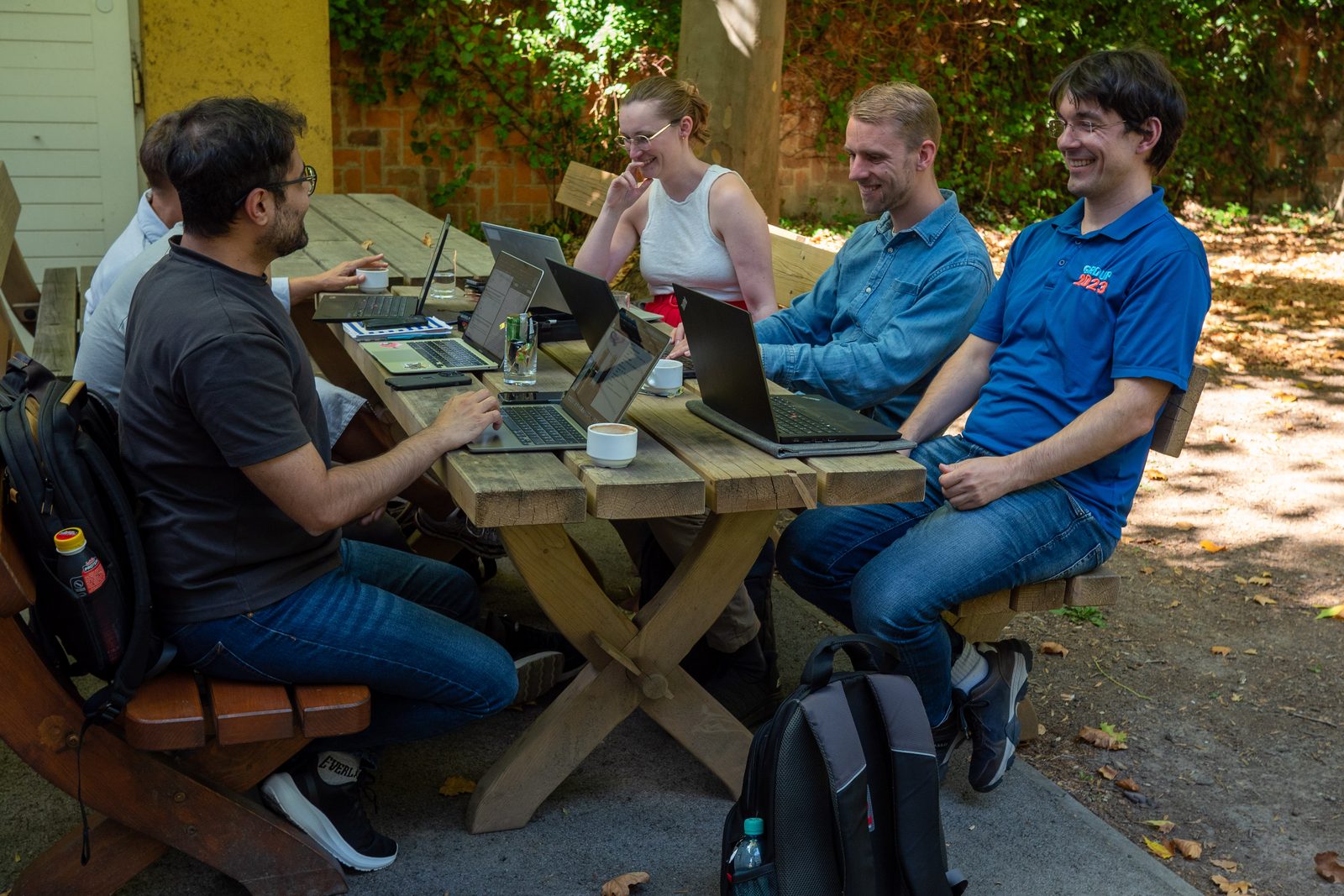 Gruppenarbeit an Laptops im Hof